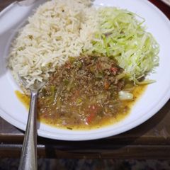 A picture of Rice with ndengu and steamed cabbage.