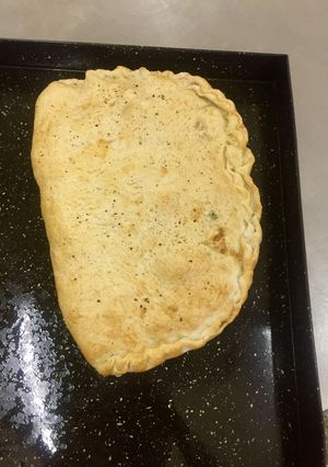 Una foto de Calzone de salchicha ahumada y espinaca