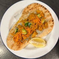 Chicken tikka on naan with fragrant salad A picture of Chicken tikka on naan with fragrant salad.