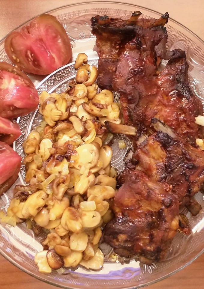 Una foto de Costillas marinadas en salsa de tomate, ketchup y mostaza con salteado de champiñones