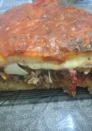 Una foto de Pizza rellena de carne, huevos, jamón y muzzarella