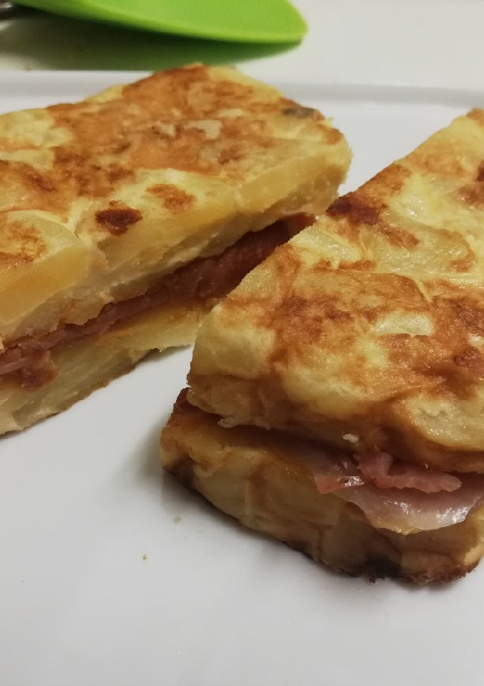 Una foto de Tortilla de papas rellena de mojo picón y jamón