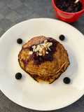 Pancakes de avena en hojuelas y banano con salsa de frutos rojos