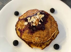 Una foto de Pancakes de avena en hojuelas y banano con salsa de frutos rojos