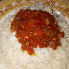 A picture of White rice and tomatoes sauce.