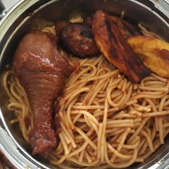 A picture of Spaghtti with fried plantain and chicken.
