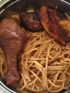 A picture of Spaghtti with fried plantain and chicken.