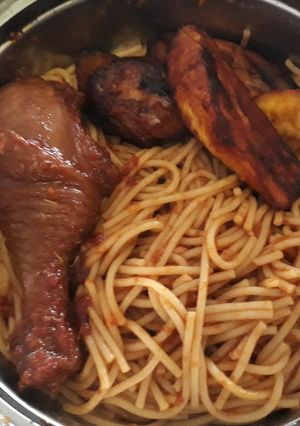A picture of Spaghtti with fried plantain and chicken.