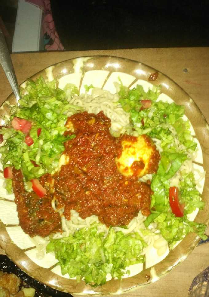 A picture of Spaghetti and macaroni with stew and salad,fish and egg.