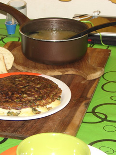 Una foto de Tortilla de espinaca rellena con quesos acompañada de una sopa montañesa y pan casero