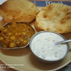 A picture of Bhatura, Chana and boondi raita.