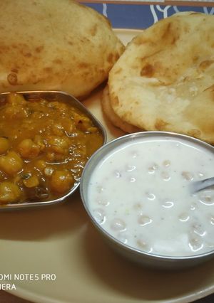 A picture of Bhatura, Chana and boondi raita.
