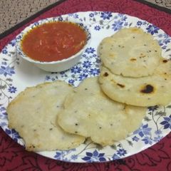A picture of Rice flour paratha with tomato chutney.
