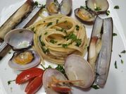Una foto di frutti di mare e linguine