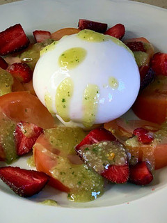 Una foto de Ensalada de tomate, fresas, burrata y pesto de piñones