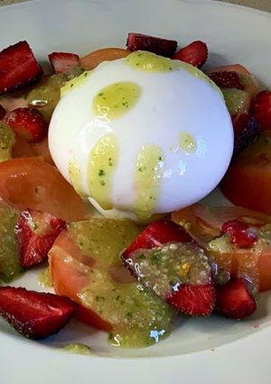 Una foto de Ensalada de tomate, fresas, burrata y pesto de piñones