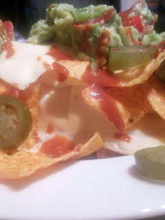 Una foto de Nachos con guacamole y queso