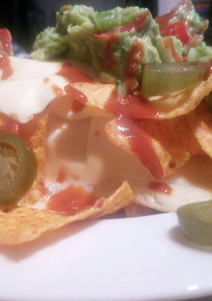 Una foto de Nachos con guacamole y queso