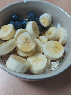 Una foto de Bol de avena, frutos secos, fruta, miel y yogurt cremoso