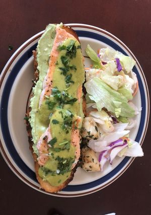 Una foto de Tostada de salmón picante con crema de aguacate y queso de cabra