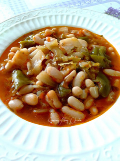 Una foto de Alubias blancas con tomates y repollo, todo orgánico