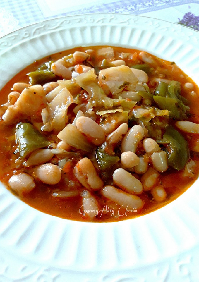 Una foto de Alubias blancas con tomates y repollo, todo orgánico