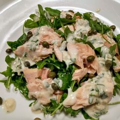 A picture of Poached salmon and arugula with creamy tarragon dressing.