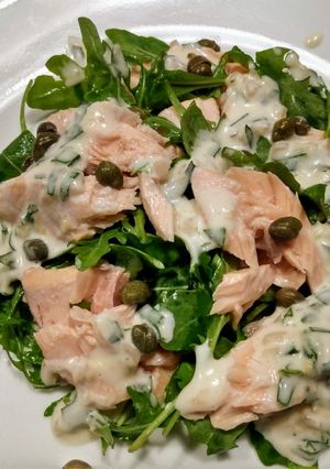 A picture of Poached salmon and arugula with creamy tarragon dressing.