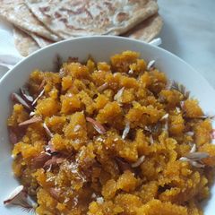 A picture of Sooji ka bikhra halwa with parathay.
