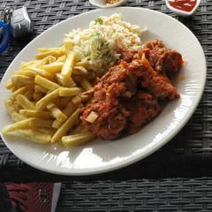 A picture of Chips,coleslaw and sauced meat.