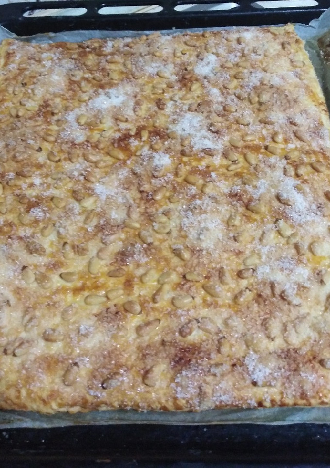 Una foto de Coca de crema y piñones