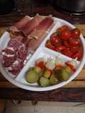 Tomates cherry al ajillo con fuet, jamón serrano y encurtidos