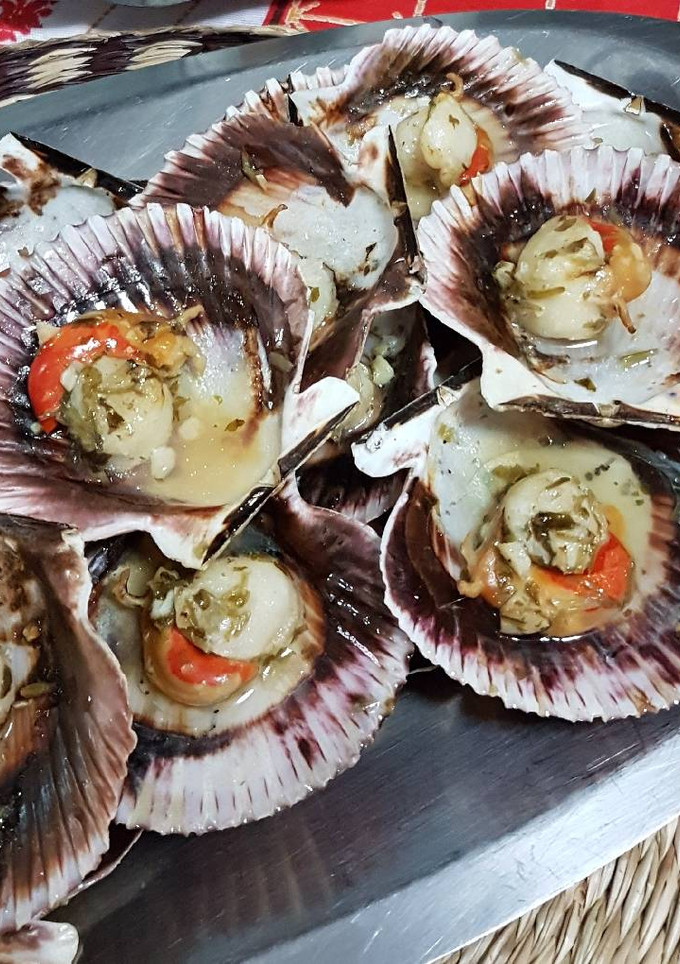 Una foto de Zamburiñas al horno con aceite de ajo y perejil