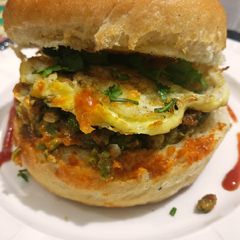 A picture of Cheese, egg, veggies stuffed burger.