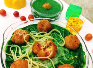 A picture of Risotto Balls with Spinach Sauce and baked Spaghetti.