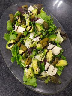 Una foto de Ensalada de brotes tiernos, aguacate y rulo de cabra