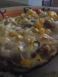 Pizza de jamón, queso parmesano y vegetales