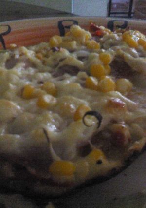 Una foto de Pizza de jamón, queso parmesano y vegetales