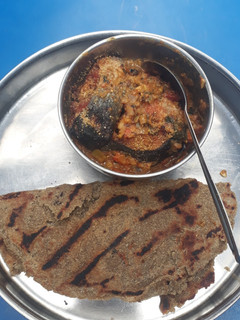 A picture of Fish in gravy with bajra roti.