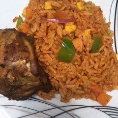 A picture of Jollof rice with grilled chicken.