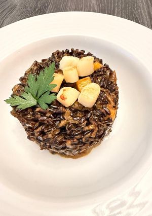 Une photo de Risotto noir Vénéré aux noix de Saint-Jacques