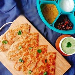 A picture of Aloo ke parathe with green chutney.