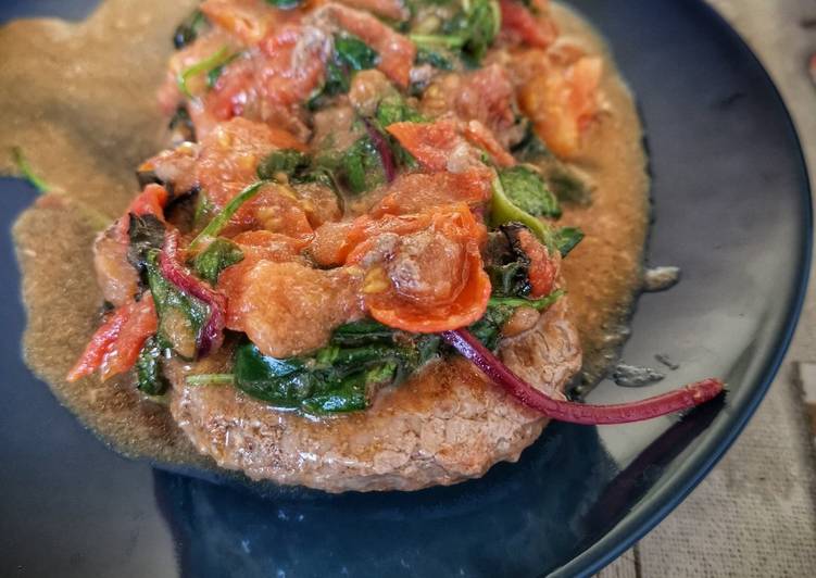 Hamburger con pomodori freschi e insalata mista cotti in padella