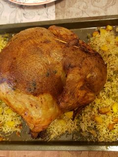 A picture of Chicken stuffed with rice, potatoes and green peas.