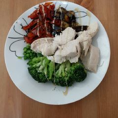 A picture of Poached chicken breast and roasted veggies bowl.
