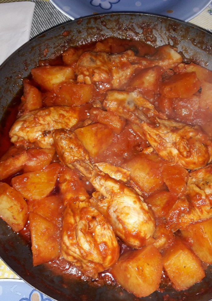 Una foto de Delicioso Pollo en jugo de tomate acompañado de Papas y olivas negras