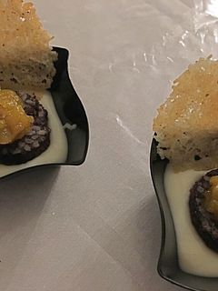 Una foto de Morcilla de Burgos con chutney de peras y crujiente de queso Manchego sobre parmentier de papa