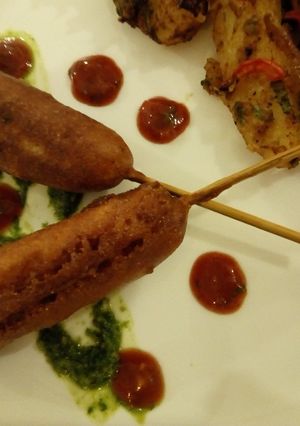 A picture of Corn Dogs with grilled potatoes.