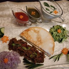 A picture of Beef shawarma With pita bread and sauces.