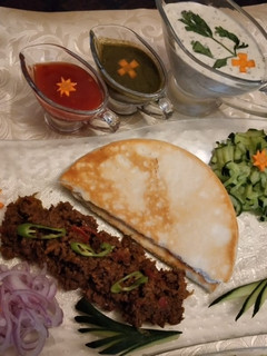 A picture of Beef shawarma With pita bread and sauces.